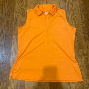 Look cute on the golf course with this orange sleeveless Slazenger golf shirt.